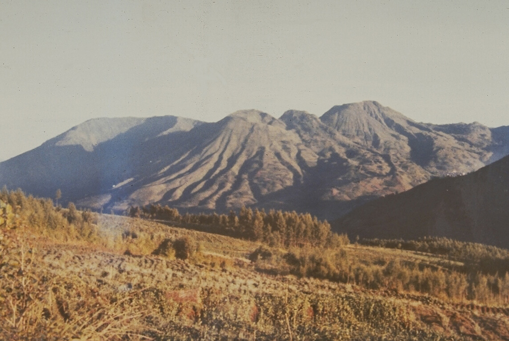 The Dieng volcanic complex, seen here from the SE, has numerous small craters and cones of Pleistocene-to-Holocene age over an area of 6 x 14 km. Minor phreatic eruptions have occurred in historical time, sometimes associated with hazardous gas emissions. The volcanic terrain of the Dieng plateau contains the oldest temples in Java. Photo by Sumarma Hamidi, 1973 (Volcanological Survey of Indonesia).