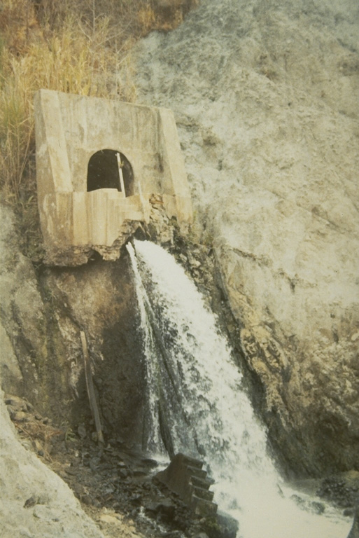 The outlet tunnel of the Kelud crater lake drainage system in 1973. A series of drainage tunnels and shafts were constructed following the devastating 1919 eruption that killed 5,110 people to decrease the amount of water in the summit crater lake. Loss of life from devastating lahars produced by the explosive ejection of crater lake water has been significantly reduced in subsequent eruptions. The original outlet was lowered to this level following the deepening of the crater by an eruption in 1951. Photo by Sumarma Hamidi, 1973 (Volcanological Survey of Indonesia).