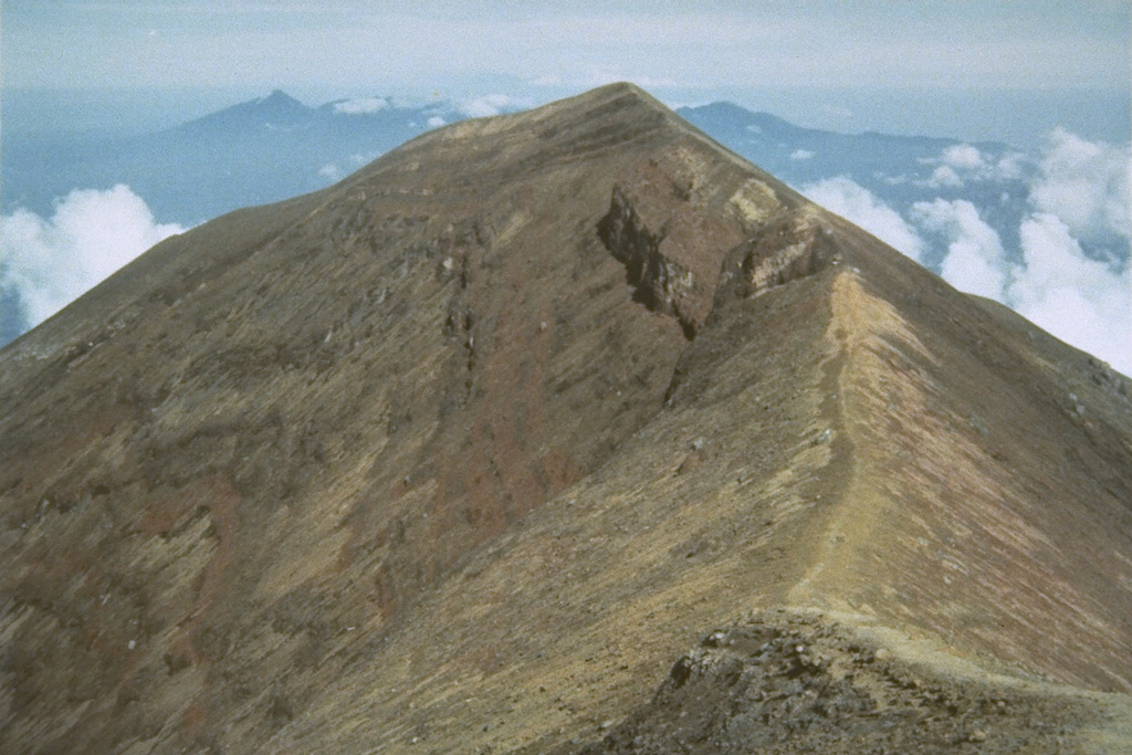 The summit of Agung marks the highest point on the island of Bali. The broad irregular massif in the far distance is the 11 x 6 km wide Bratan caldera. Photo by Sumarma Hamidi, 1973 (Volcanological Survey of Indonesia).