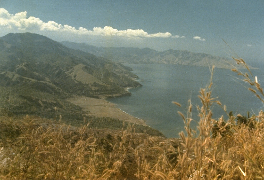 A landslide in 1979, not associated with an eruption, originated from the northern end of the Iliwerung volcanic massif.  The resulting debris avalanche swept into the Indian Ocean at a high velocity and produced a tsunami that scoured the shoreline of Lembata (Lomblen) Island, killing more than 500 people.  The extent of the runup of the tsunami can be seen forming the flat barren area in the center of the photo, which was taken from the SW on 27 July 1979, shortly after the tsunami. Photo by Ruska Hadian, 1979 (Volcanological Survey of Indonesia).