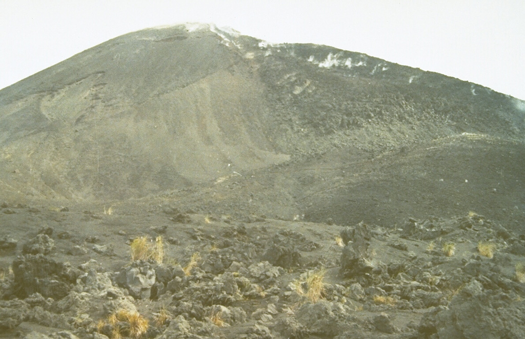 During an eruption in 1966-67, a lava dome was emplaced at the summit of Soputan.  A blocky lava flow, seen here steaming along the right-hand skyline from the NE-flank cone of Aeseput, descended its flanks.  The eruption began with a vulcanian explosion on May 21, and lava outflow began June 12-15, resumed again in November, and continued until November of the following year.  An explosive eruption accompanied by pyroclastic flows took place on September 25, 1966. Photo by Ruska Hadian, 1973 (Volcanological Survey of Indonesia).
