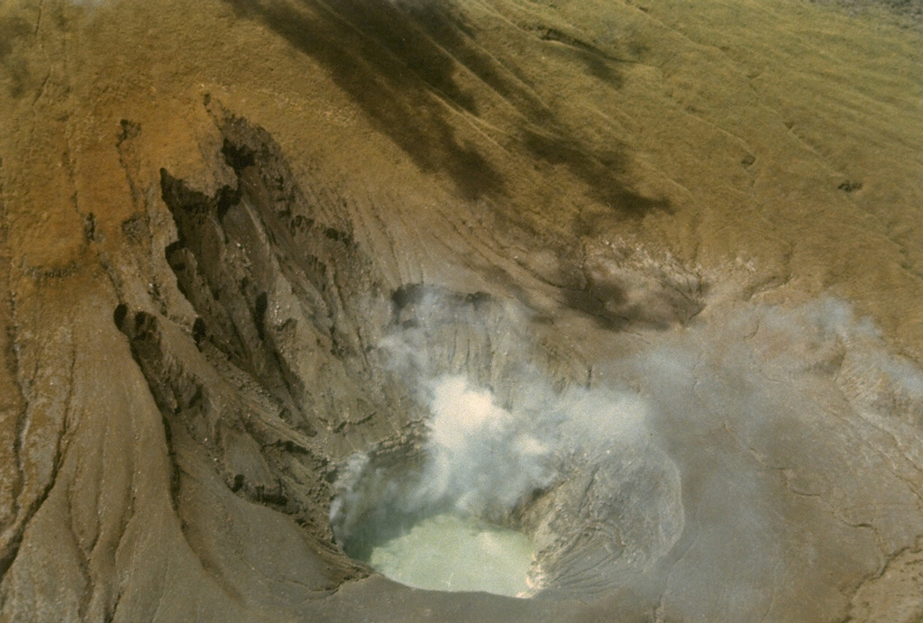 Steam rises from fumaroles on the wall of Tompaluan crater in May 1985 during a quiescent period at the frequently active volcano.  The crater, which has been the source of most historical eruptions from Lokon-Empung volcano, lies in a saddle between the two peaks.  The floor of the 250 x 150 m wide crater sometimes contains a small lake. Photo by Ruska Hadian, 1985 (Volcanological Survey of Indonesia).