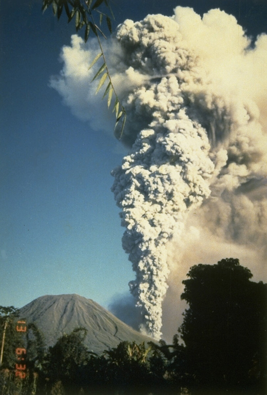 A large eruption plume plume rises above Tompaluan crater in the saddle between Lokon (left) and Empung volcanoes on May 13, 1987, the final day of a period of intermittent eruptions that began in March 1986.  The initial explosions on March 22 and 24 and May 10 ejected the crater lake water, and lahars occurred during the latter two days.  Ashfall during the eruption damaged house roofs and rice fields. Photo by S.R. Wittiri, 1987 (Volcanological Survey of Indonesia).