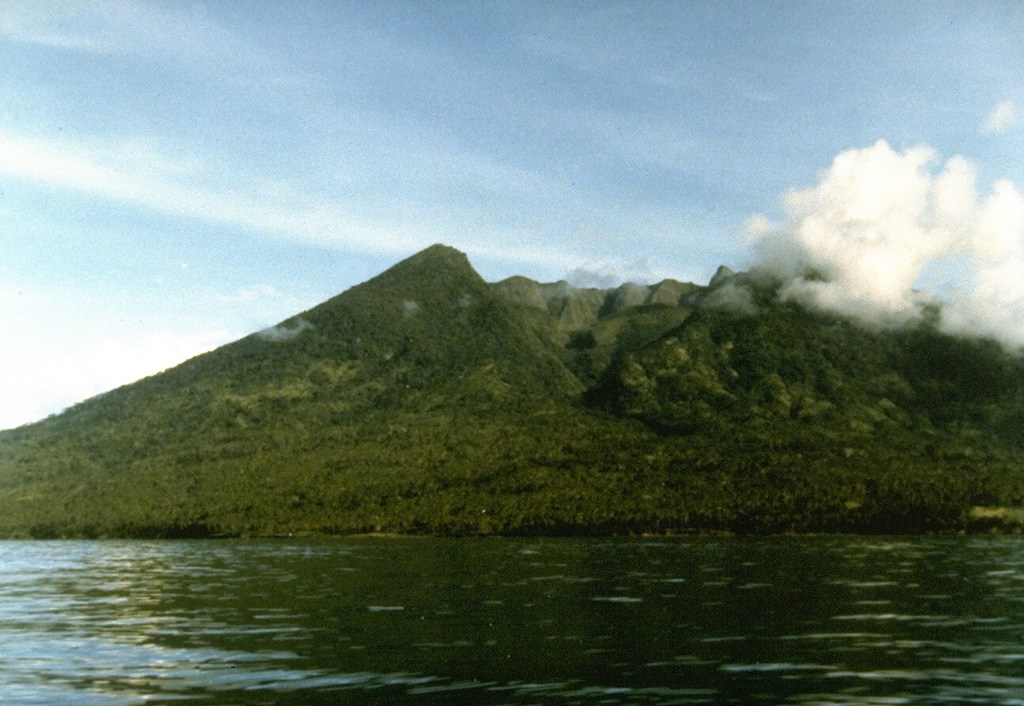 Makian volcano, one of a chain of islands off the western coast of Halmahera Island, has been the source of infrequent, but violent eruptions that have devastated villages on the 10-km-wide island.  The large summit crater containing a small crater lake on the NE side is drained by two steep-walled valleys.  The northern valley, Barranco Ngopagita is seen in this view from the NW. Photo by Ruska Hadian, 1985 (Volcanological Survey of Indonesia).
