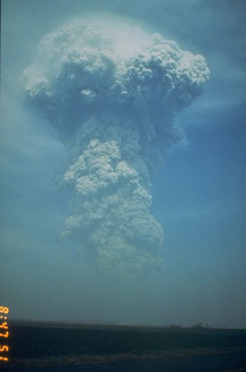 A large ash plume rises above the NW flank of Pinatubo at 0841 on 13 June 1991. Weather radar indicated that the plume reached an altitude of at least 24 km. Pyroclastic flows from this eruption extended 4-5 km down the Maraunot drainage on the NW flank. At the end of this eruption the NW-flank lava dome that had begun growing on 7 June was still intact. Photo by Rick Hoblitt, 1991 (U.S. Geological Survey).