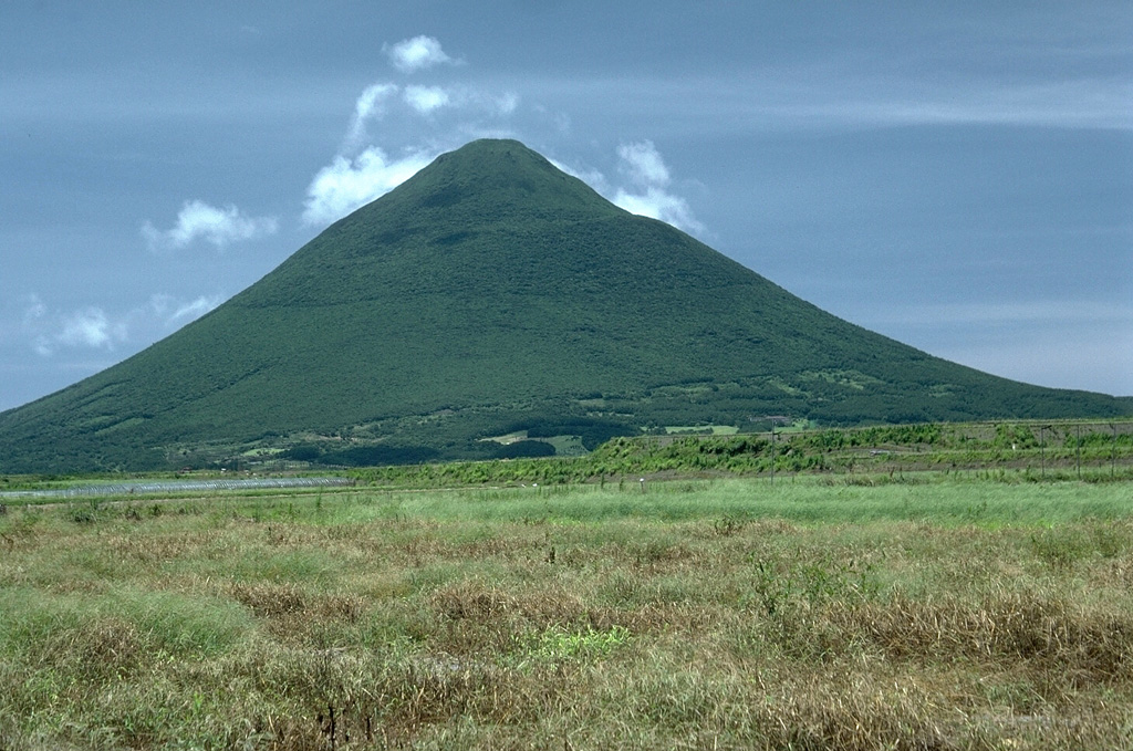 Kaimon volcano is the youngest and most prominent feature of the Ibusuki volcanic field at the southern tip of Kyushu, seen here from the N. It was constructed during the last 4,000 years and has been the source of historical eruptions in the volcanic field. The Ibusuki field is located W of the Pleistocene Ata caldera and contains numerous small cones, maars, and the 4.5-km-wide Ikedoko caldera. Photo by Lee Siebert, 1988 (Smithsonian Institution).