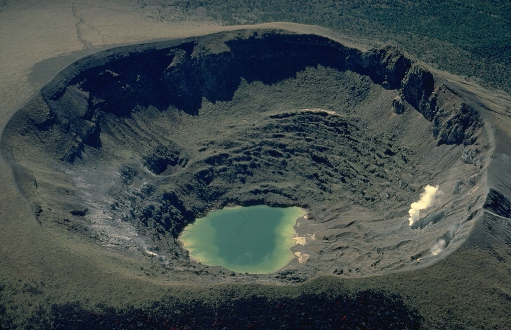 A small lake occupies the floor of Shinmoe-dake crater and a persistent fumarole plume rises from its western wall.  Shinmoe-dake is one of the most active volcanoes of the Kirishima volcano group in Kyushu.  Small-to-moderate explosive eruptions have occurred from the 700-m-wide crater since the 17th century. Copyrighted photo by Katia and Maurice Krafft.