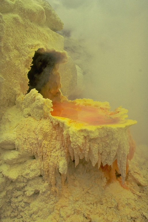 Liquid molten sulfur at a thermal area of the Kuju volcanic complex on the southern Japanese island of Kyushu drips over the lip of the small fumarolic vent.  The sulfur then solidifies, forming these beautiful stalactite-like features on the side of the vent. Copyrighted photo by Katia and Maurice Krafft, 1981.