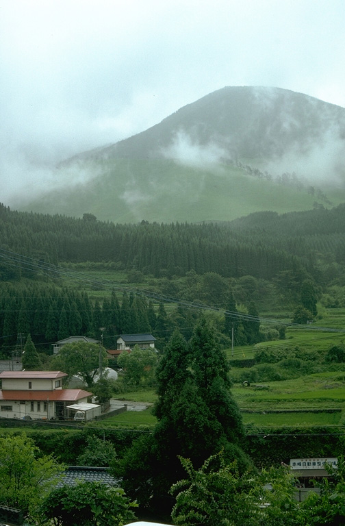 The Kuju Volcano Group consists of more than ten cones and lava domes NE of Aso caldera. Mimatayama, seen here at the NW side of the complex, has a summit lava dome. The first recorded eruptions were of phreatic or hydrothermall activity in the 17th and 18th centuries. Many hot springs and hydrothermal fields are located at the Kuju complex. A fumarole on Hosho lava dome was the site of a sulfur mine for at least 500 years. Photo by Lee Siebert, 1988 (Smithsonian Institution).