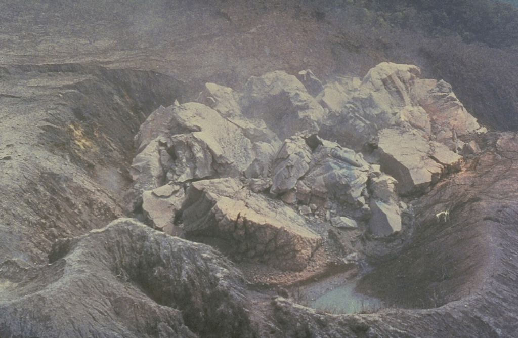 This closeup view on 20 May 1991 shows the first lava extrusion of the 1990-95 dome of Unzen volcano in Japan. The dome was extruded in the Jigokuato crater, which was formed by an explosion on the first day of the eruption, 17 November 1990. By 23 May the dome had reached a height of 44 m with a diameter of 110 m. It proceeded to grow over the east crater rim (upper right). Periodic collapse of the steep front of the dome produced pyroclastic flows that traveled progressively farther down the Mizunashi valley.  Photo courtesy Shimbara Earthquake and Volcano Observatory, 1991.