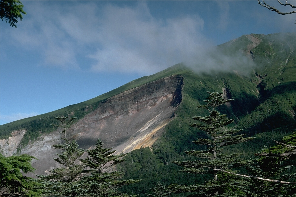 The most prominent feature on the upper SE flank of Ontakesan volcano is the headwall scarp of a volcanic landslide. The landslide occurred on 14 September 1984 with no associated eruptive activity. The resulting debris avalanche traveked 13 km down the Nigori and Otaki river valleys. Photo by Lee Siebert, 1988 (Smithsonian Institution).