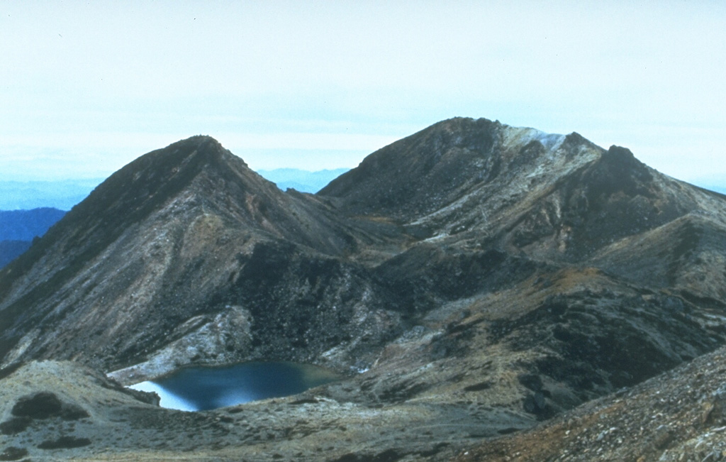 Kengamine (left) and Gozengamine (right) peaks are seen from Onanjimine, another of the summit peaks of Hakusan volcano. The Kengamine lava dome and the Shiramizutaki lava flow extending from its base originated during an explosive eruption about 2,300 years ago. A pond fills the Midorgaike crater in the left foreground, which formed during an explosive eruption in 1042 CE. Photo by Toshio Higashino (Haku-san Nature Conservation Center).