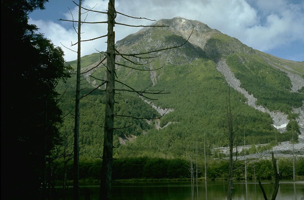 Yakedake rises above Kamikochi resort in the Northern Japan Alps, seen here from Taishoike pond to its ENE. It contains a 300-m-wide crater at the summit and craters are found on the SE and N flanks. Frequent small-to-moderate phreatic eruptions have occurred during the 20th century from both summit and flank vents. An eruption in 1915 produced a lahar that created Taishoike pond and killed the trees in the foreground. Photo by Lee Siebert, 1977 (Smithsonian Institution).