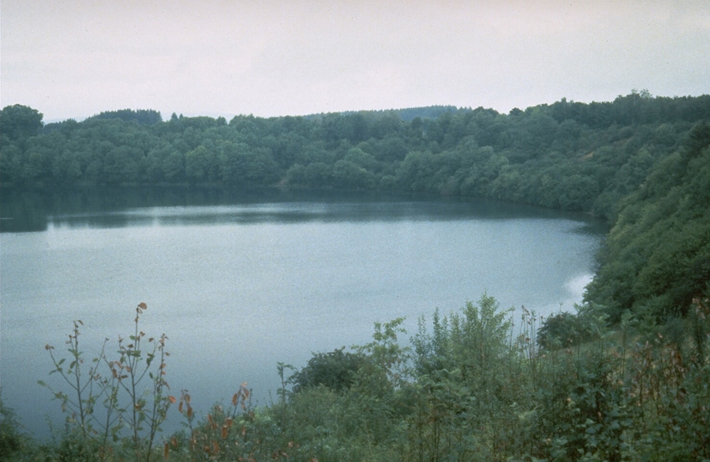 The lake-filled Weinfelder maar is one of about 80 maars of the West Eifel Volcanic Field in Germany, west of the Rhine River. The roughly 500-m-wide crater was formed during the late Pleistocene by explosions through non-volcanic bedrock. About 230 eruptions during the past 730,000 years formed a 600 km2 area that includes maars, scoria cones, and small stratovolcanoes. Photo by Richard Waitt, 1990 (U.S. Geological Survey).
