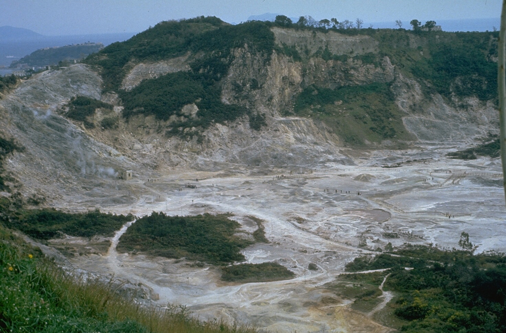 The Solfatara maar-diatreme in the Campi Flegrei caldera was formed during an explosive eruption about 3,850 years ago. The crater is still thermally active, releasing gas that includes H2O, CO2, and CO. A small phreatic eruption occurred at Solfatara in 1198 CE. Photo by Roberto Scandone, 1984 (University of Rome).