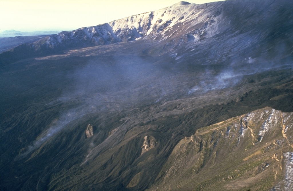 An aerial view looking SW across the Valle del Bove on 6 December 1986 shows a lava flow descending the floor of the broad depression on Etna's E flank. The eruption began on 30 October from a 2-km-long fissure that cut the upper Valle del Bove, and lasted until 27 February 1987. Lava flows traveled 5 km E to 1,325 m altitude. Photo by Romolo Romano, 1986 (IIV-CNR, Catania, Italy).