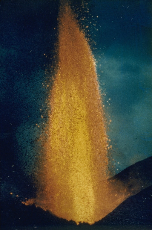 A lava fountain rises above the Kitazungurwa vent on the S flank of Nyamuragira on 1 August 1986. This eruption began on 16 July from a vent 4.5 km from the southern rim of the caldera. It produced lava flows that traveled to the SW to within a few kilometers of Lake Kivu. Photo courtesy of Henry-Luc Hody, 1986 (Belgian ambassador).