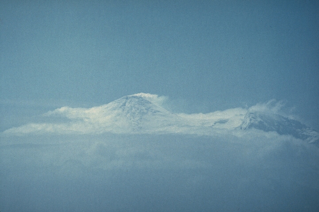 A plume, seen here from a ship to the SW, drifts from the summit of Heard volcano on 14 January 1985. Incandescence and a lava flow were observed that night from the ship 25 km offshore and an eruption plume was visible for two days. Eruptive activity may have continued into 1987. An active lava lake in a new crater was observed during a December 1986-January 1987 summit expedition. A lava flow, probably dating back to January 1985, was seen descending 8-9 km from the summit. Photo by André Giret, Expéditions Polaires Françaises, 1985.