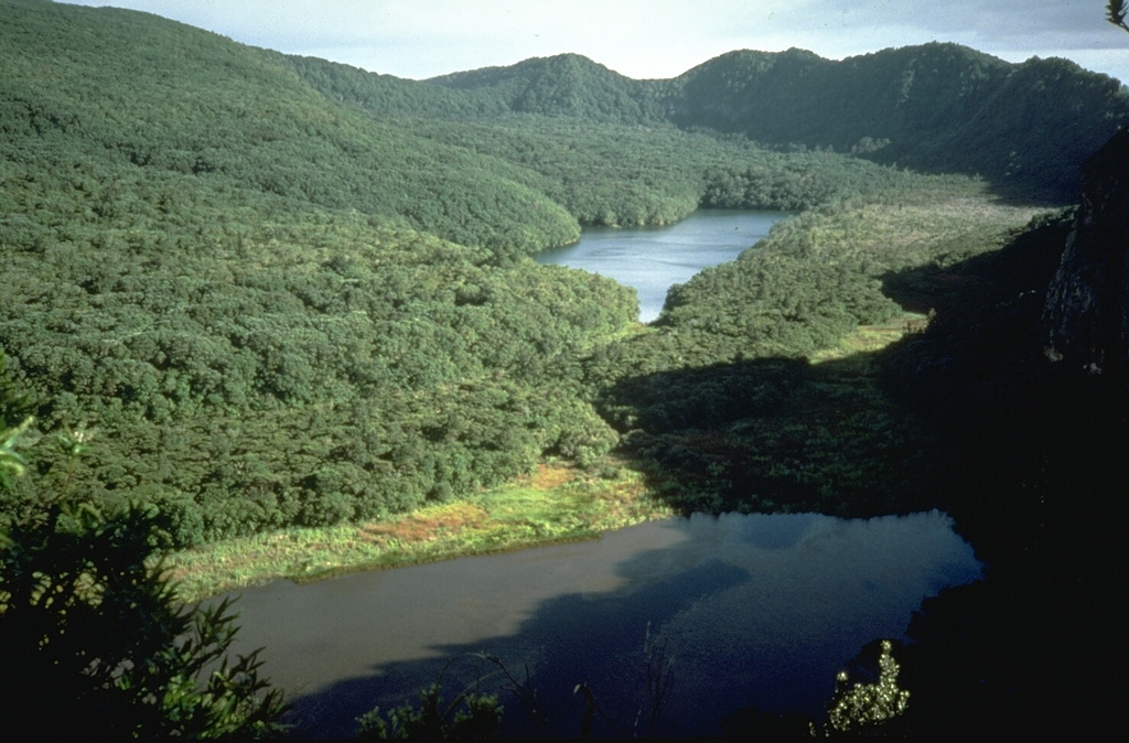 The caldera wall at the upper right was created during the youngest caldera-forming eruption of Mayor Island about 6,300 years ago. Major explosive eruptions at this time produced more than 1 km3 of tephra that deposited across the Bay of Plenty in the North Island. The 2.2 x 2.5 km wide caldera was subsequently partially filled by lava flows and domes, the latest of which may have been erupted as recently as 500-1,000 years ago. Photo by Richard Waitt, 1986 (U.S. Geological Survey).