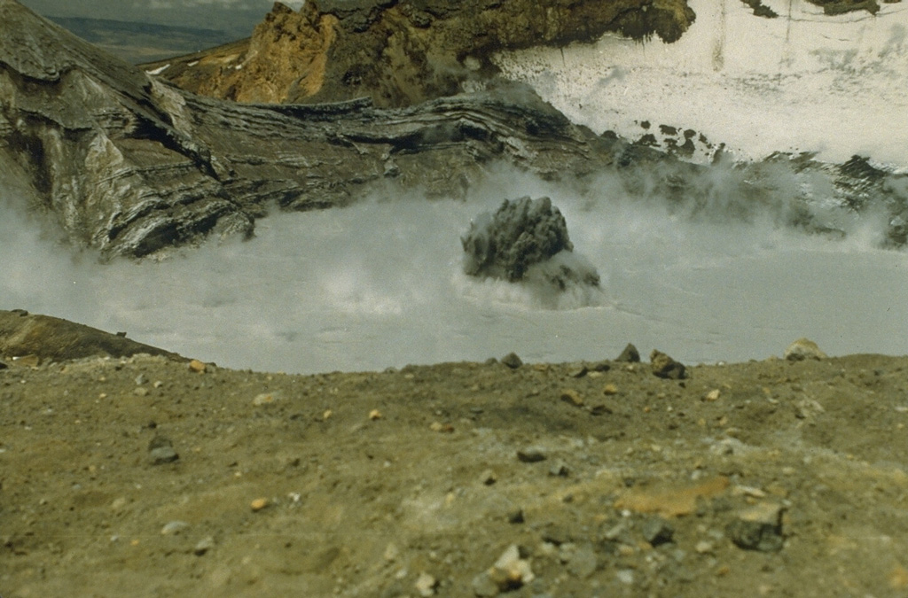 A series of minor phreatic eruptions, such as this one on 21 February 1982, took place from Crater Lake at the summit of Ruapehu volcano from October 1981 until April 1982. This eruption, seen here from the crater rim, is small compared to others that have taken place at Crater Lake. Photo by Brad Scott, 1982 (New Zealand Geological Survey).