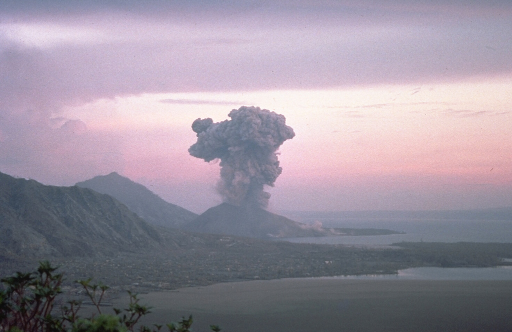 Eruptions from Tavurvur and Vulcan began within about an hour of each other on 19 September 1994. Powerful explosions from Vulcan produced ash plumes estimated to be as high as 21-30 km, pyroclastic flows that extended about 3 km, and the large rafts of floating pumice seen in the foreground of this photo. About 53,000 people were evacuated from Rabaul and surrounding areas, and there were few fatalities. Vulcan stopped erupting on 2 October, but Tavurvur, seen here from the NW in October, continued erupting into 1995. Photo by Elliot Endo, 1994 (U.S. Geological Survey).