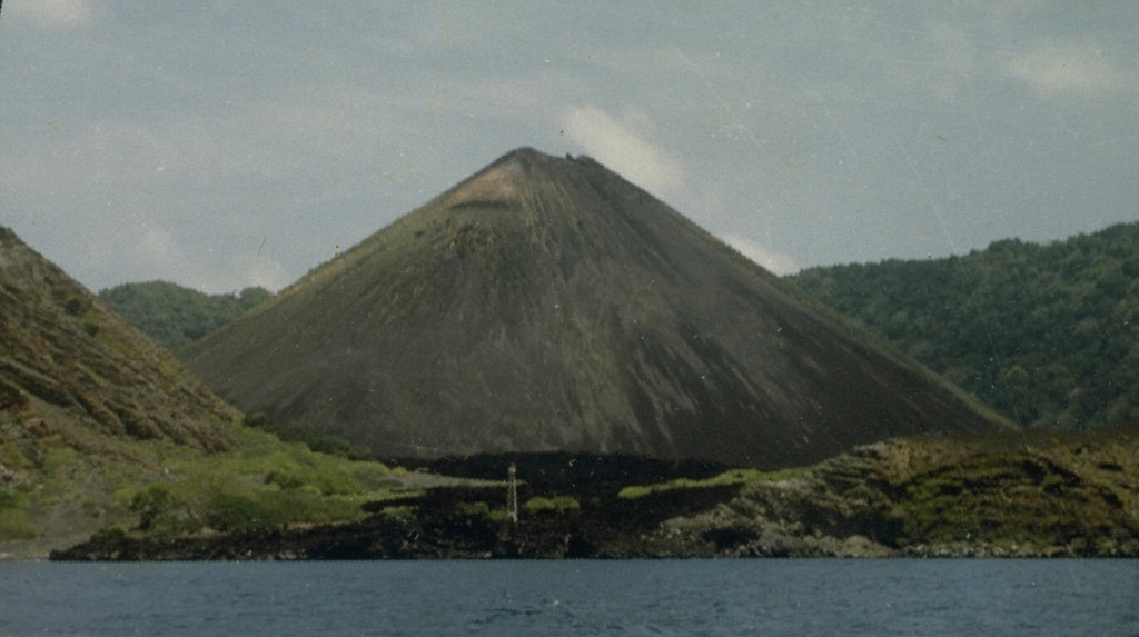 Prior to the 1991 eruption, the central scoria cone in the crater of Barren Island was 305 m high with a 60-m-wide crater at its summit. The black lava flow in the foreground erupted during 1803-1804 and extends from the base of the cone to the west coast. This lava flow was the first known in historical time from Barren Island. Photo courtesy of D. Haldar, 1990 (Geological Survey of India).
