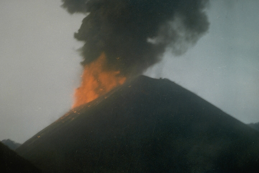 Incandescent ejecta and an ash plume from Strombolian eruptions that began in April 1991 are seen in this 16 May 1991 view of the scoria cone in the center of Barren Island. The 1991 eruption was the first from Barren Island in the 20th century. Photo  courtesy V.K. Raina, 1991 (Geological Survey of India)