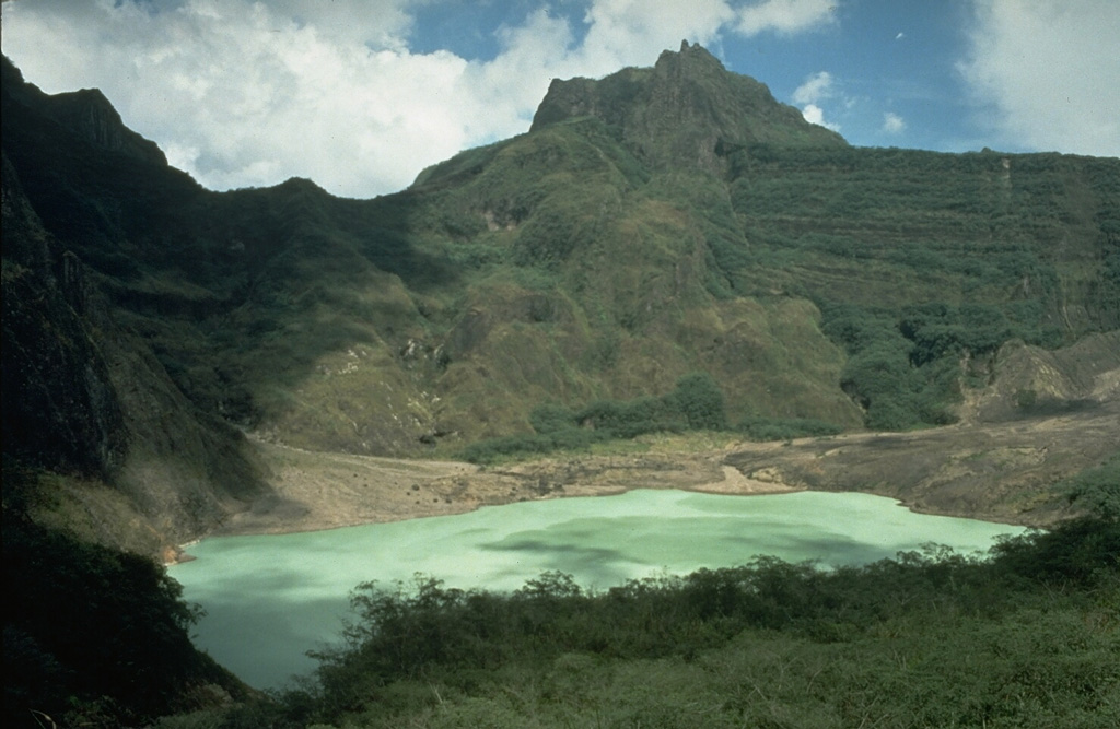 The broad, irregular summit of Kelud volcano contains several lava domes and a crater lake that has been the source of frequent violent and sometimes devastating eruptions. Construction of outlet tunnels following an eruption in 1919 that killed 5,110 people has reduced the number of fatalities from pyroclastic flows and lahars during subsequent eruptions. Photo by Dan Dzurisin, 1980 (U.S. Geological Survey).