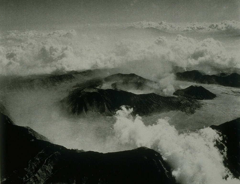 Tengger caldera is about 16 km wide and 500 m deep. Seven eruptive centers are on the floor of the flat-bottomed Sandsea caldera, the youngest at the compound Tengger caldera. The cluster of post-caldera cones was constructed along E-W and NNE-SSW fracture zones. Bromo is the active cone in this view from the south. Bromo crater is around 600 x 700 m and contains a terrace indicating the migration of its eruptive center to the north. Photo by Indonesia Department of Information (published in Green and Short, 1971, 