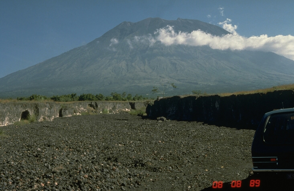 Agung is located at the eastern end of the island of Bali. A 200-m-deep crater is located at the summit of the volcano, seen here from the Sakta River on the eastern flank. Eruptions have been recorded in historical time including an episode during 1963-64 that produced devastating pyroclastic flows and lahars. Photo by Tom Pierson, 1989 (U.S. Geological Survey).