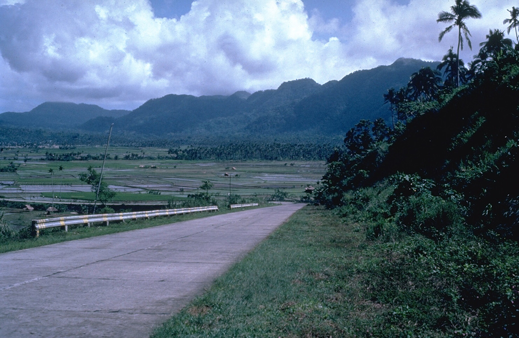 The southern wall is the most prominent segment of the 11-km-wide Irosin caldera, and overlooks the flat caldera floor below the active Bulusan volcano. The northern caldera rim has been buried by the flanks of Bulusan and other post-caldera cones. Photo by Chris Newhall (U.S. Geological Survey).