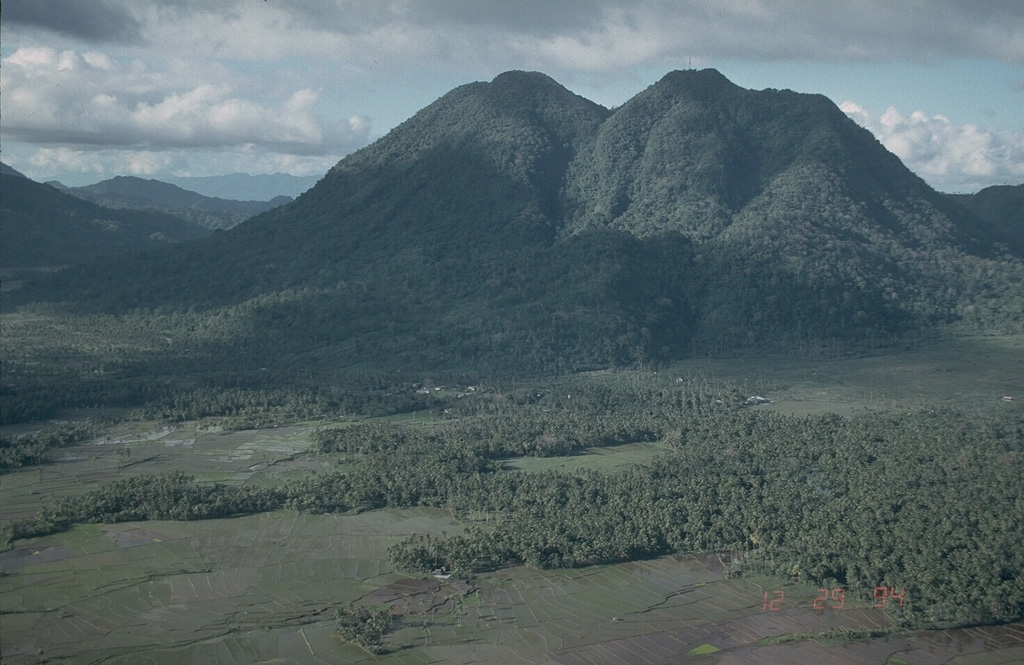 Mount Jormajan, a large lava dome on the east side of Bulusan volcano, was constructed at the W side of the 11-km-wide Irosin Caldera. This view from the south shows the flat caldera floor in the foreground, with the western caldera wall visible to the far left. Photo by Chris Newhall (U.S. Geological Survey).