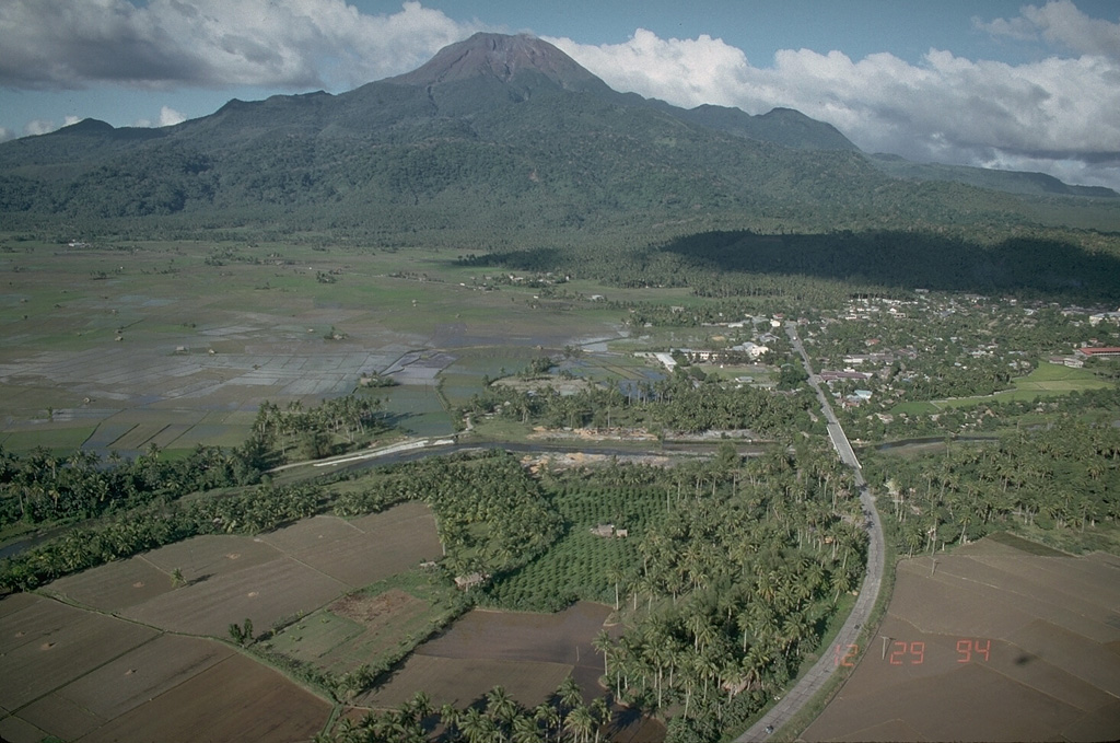Bulusan, seen here from the south, rises above the low-lying floor of Irosin caldera and is the youngest of several cones and lava domes constructed within the caldera. The city of Irosin is the largest community within the caldera, which formed more than 36,000 years ago. Historical eruptions of Bulusan have occurred at summit vents and flank vents also are found low on the SE side. Photo by Chris Newhall (U.S. Geological Survey).