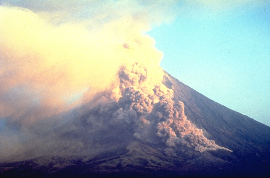 A small pyroclastic flow descends the Bonga valley on the E flank of Mayon in March 1993. Collapse of a lava flow front traveling down the valley produced many small pyroclastic flows during the 1993 eruption. A large pyroclastic flow on 2 February, the first day of the eruption, traveled 6 km down this same valley and killed 75 people. Photo by Philippine Institute of Volcanology and Seismology, 1993.