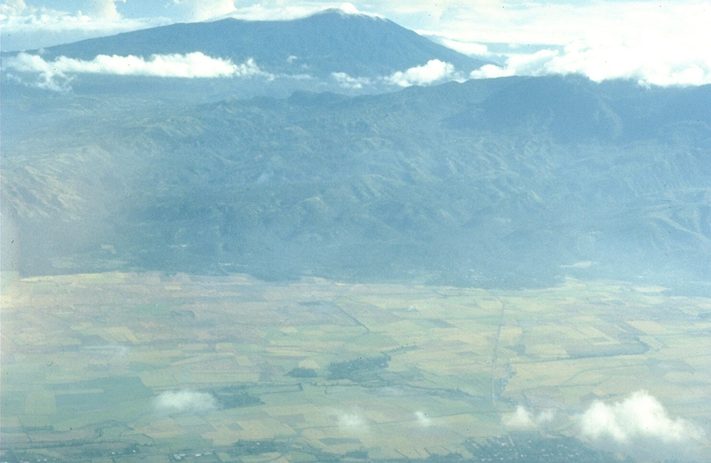 Malinao is seen here in the background of this aerial view looking to the NE with the small town of Polangui in the foreground. It contains a summit crater that opens towards the N. The ridge in the center of the photo is the W flank of Masaraga volcano. Photo by Chris Newhall (U.S. Geological Survey).