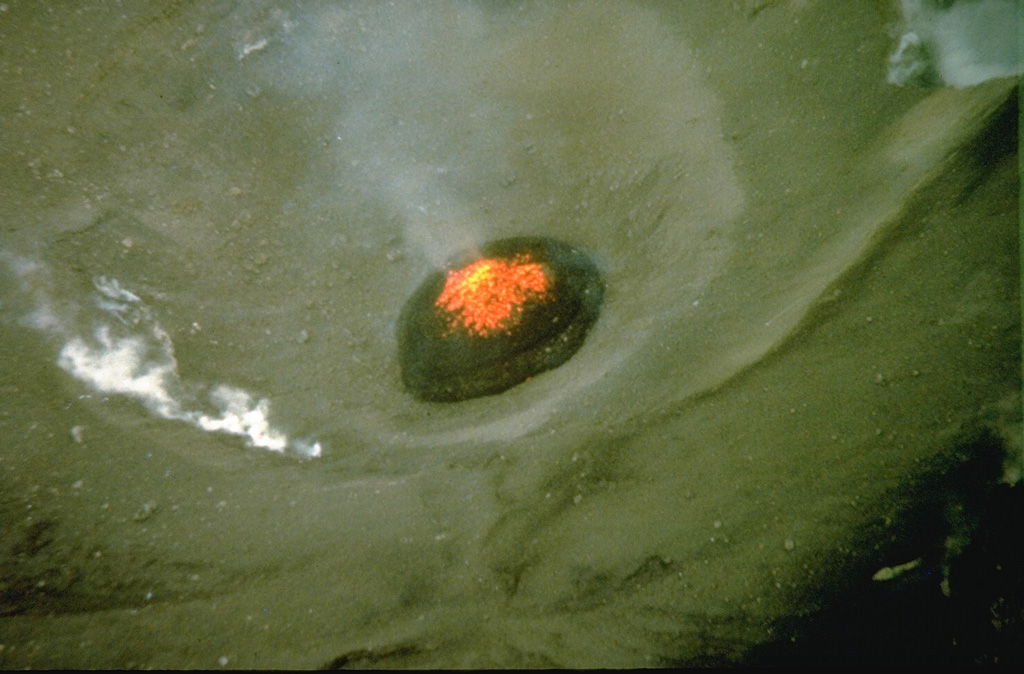 An incandescent lava dome is visible in the Minamidake crater of Sakurajima in this 9 September 1981 aerial view. Sakurajima has been in near-continuous activity since 1955, with frequent mild-to-moderate explosions that commonly produce ashfall on the island. Photo by Norm Banks, 1981 (U.S. Geological Survey).