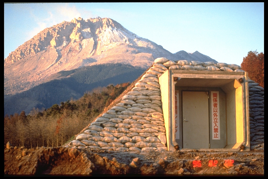 Starting in 1991 a lava dome grew at the summit of Fugendake in the Unzen volcanic complex. By the time the eruption ended in February 1995 the dome had grown to a height of 1,500 m, about 200 m above the pre-eruption surface. This 3 February 1995 photo from the NE shows a bunker in the foreground for emergency protection from block-and-ash flows that were produced by collapse of the growing lava dome. Photo by Tom Pierson, 1995 (U.S. Geological Survey).