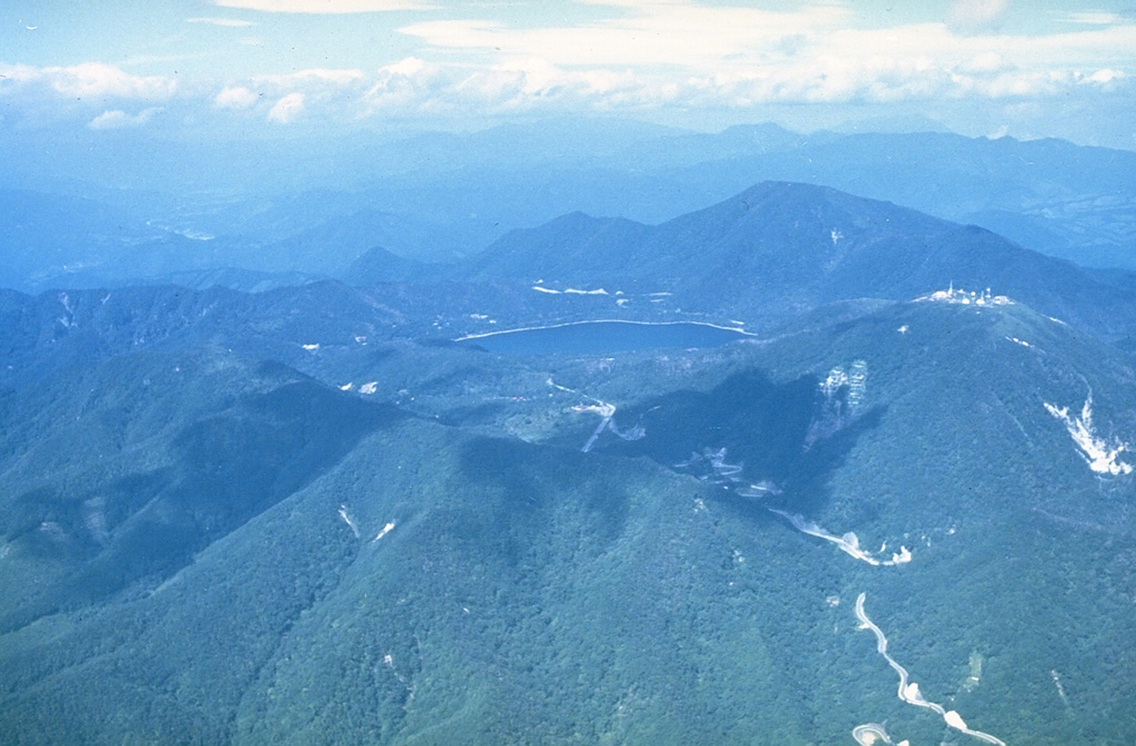Akagisan at the northern end of the Kanto Plain has a 3 x 4 km summit caldera that contains lava domes. Lake Ono, seen here from the SW with the summit of the volcano to the upper right, occupies the NE end of the caldera. Most of the activity occurred during the Pleistocene when a series of large Plinian eruptions accompanied growth of a second cone.  Photo by Ichio Moriya (Kanazawa University).
