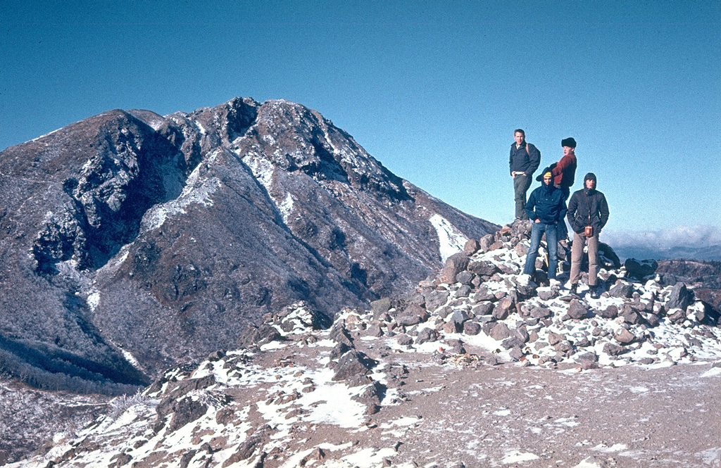 Nikko-Shiranesan is a relatively small volcano consisting of a group of four lava domes in Nikko National Park. An E-W-trending fissure is visible across the summit lava dome, seen here from Mae-Shirane, E of the summit. Eruptions from the 17th to 19th centuries CE consisted of phreatic explosions from Shiranesan, the youngest lava dome. Photo by Lee Siebert, 1964 (Smithsonian Institution).