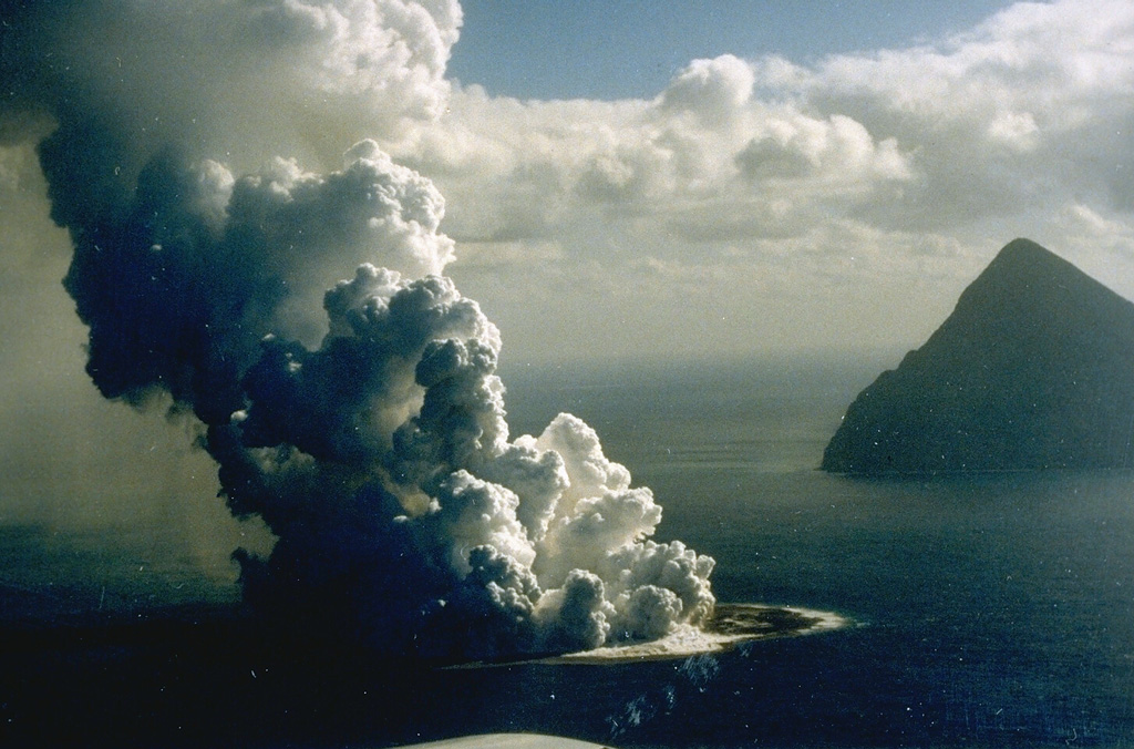 Fukutoku-Oka-no-ba is a submarine volcano located 5 km NE of Minami-Iwojima island (right). Water discoloration is frequently observed near the volcano and several ephemeral islands formed in the 20th century. The first of these created Shin-Iwojima in 1904, and the island seen in this 21 January 1986 photo; wave erosion removed the island by 8 March. Photo by G. Iwashita, 1986 (Japan Meteorological Agency).