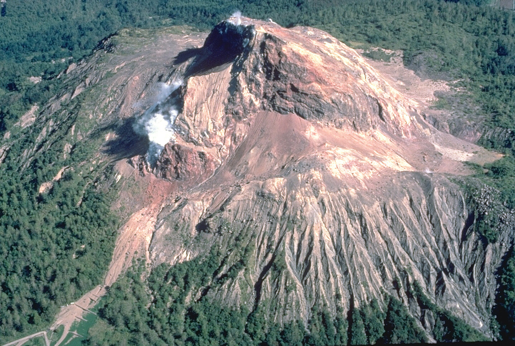Showa-Shinzan lava dome, seen here in an aerial view from the east in 1981, was born in a cornfield on the eastern flank of Usu volcano during a 1944-45 eruption.  The dome eventually rose 275 m above the pre-eruption surface.  Scientific observation was only sporadically possible during this war-time eruption.  The local postmaster, Masao Mimatsu, made careful sketches of growth of the dome that provided an invaluable record of the eruption's progress. Copyrighted photo by Katia and Maurice Krafft, 1981.