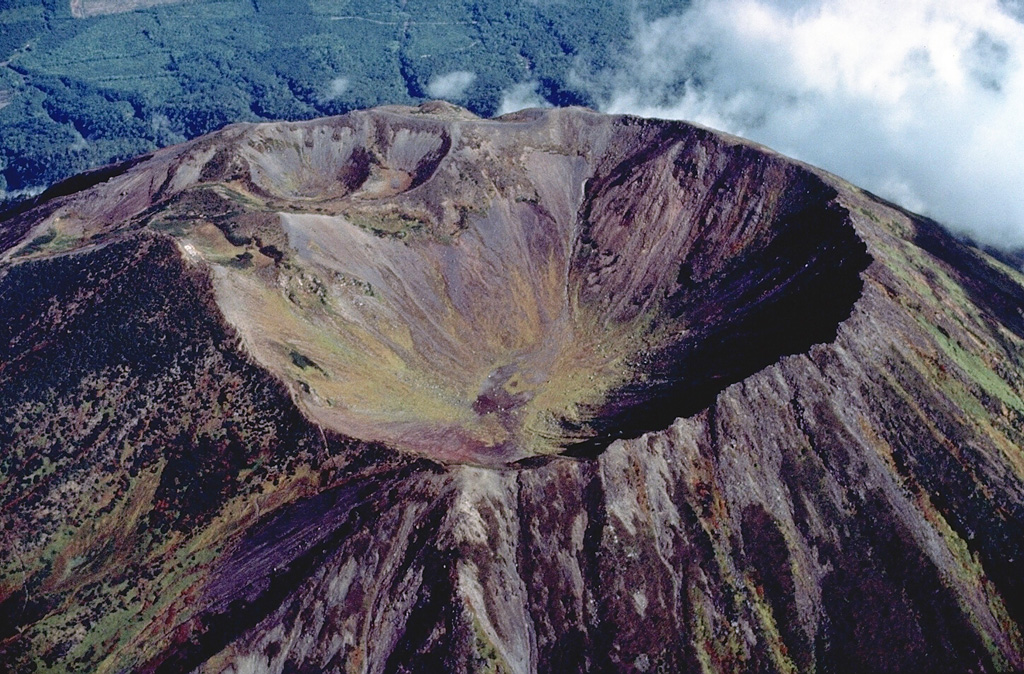 Several generations of craters can be seen at the summit of Yotei volcano in SW Hokkaido, Japan.  The principal crater of the symmetrical Yotei stratovolcano, seen here from the south, is 700 m wide.  The NW rim of the crater was later modified by eruptions that produced the two overlapping smaller craters at the upper left.  No historical eruptions are known from Yotei volcano. Copyrighted photo by Katia and Maurice Krafft, 1981.