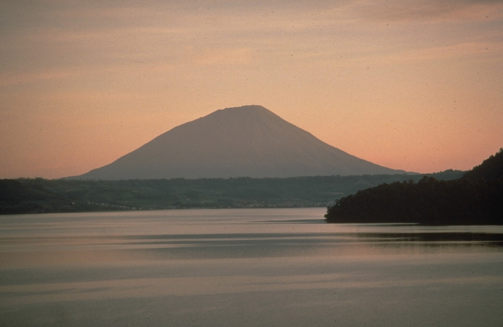 Yotei volcano is seen here to the NW above Lake Toya, which fills the 10-km-wide Toya caldera. The caldera formed during a major eruption about 110,000 years ago. A series of lava domes in the center of the lake form Nakanojima island, whose flank is in the right foreground. The photo was taken from the lower flank of Usu volcano, which formed on the southern rim of Toya caldera. Photo by Norm Banks, 1981 (U.S. Geological Survey).