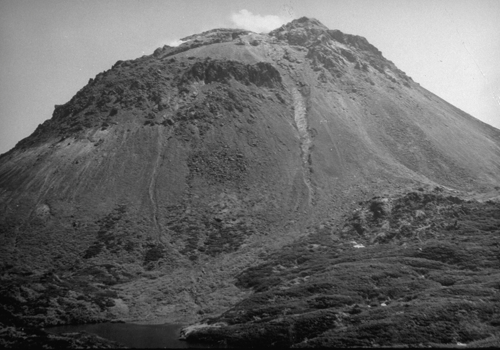 The Yakeyama (Grozny) lava dome, seen here from the N with Lake Lopastnye at the lower left, is the largest dome of the Etorofu-Yakeyama volcanic complex. The two thin light-colored areas descending from the summit region in this September 1989 view mark the paths of small lahars from a minor eruption that began in May 1989. The left-hand lahar reached the lake. The dark-colored area at the lower right is part of a series of lava flows that extend from beneath the dome's debris fan. The largest of these, on the S flank, reached 6 km to the sea. Photo by A. Samoluk, 1989 (courtesy of Genrich Steinberg, Institute for Marine Geology and Geophysics, Yuzhno-Sakhalinsk).
