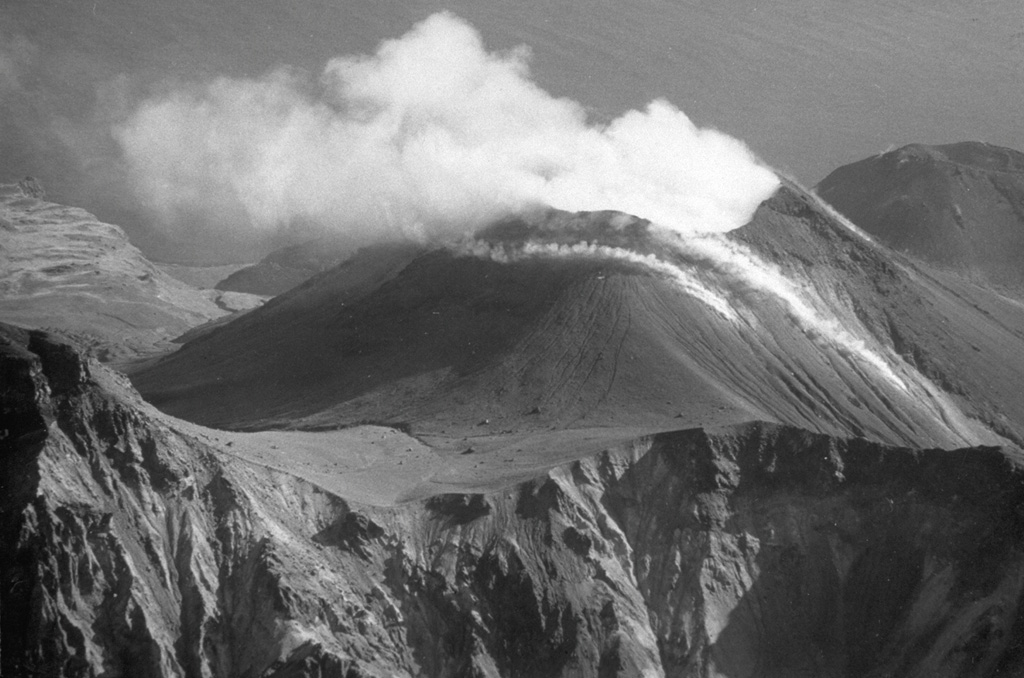 Plumes rise from the summit crater and fumarolic vents on the Cherny cone in October 1990, seen here from the NW. It contains a 330-m-wide crater with active fumaroles. Cherny is one of two cones on Chirpoi that have been recently active, with eruptions in 1712 or 1713, and 1857. Photo by A. Samoluk, 1990 (courtesy of Genrich Steinberg, Institute of Marine Geology and Geophysics, Yuzhno-Sakhalinsk).