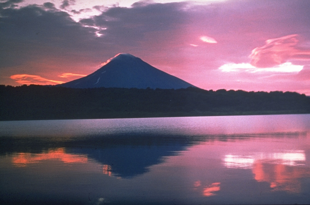 Iliinsky volcano at sunrise above the NE shore of Kurile Lake, was constructed beginning about 8,000 years ago within a 4-km-wide caldera of about the same age as the Kurile Lake caldera. It is one of several visible from the shores of one of Kamchatka's most scenic lakes. Its latest eruption, in 1901, created a 1-km-wide crater on the NE flank. The 10-km-wide Kurile Lake caldera was the source of one of Kamchatka's largest Holocene explosive eruptions about 7,600 years ago. Photo by Oleg Volynets (Institute of Volcanology, Petropavlovsk).