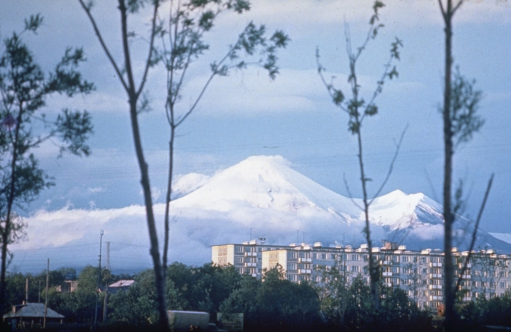 Avachinsky rises above Petropavlovsk, Kamchatka's largest city. The peak to the right is the rim of a large horseshoe-shaped crater that formed during flank collapse about 30,000-40,000 years ago and produced a major debris avalanche buried an area of about 500 km2 to the south, underlying the city of Petropavlovsk. The modern cone was constructed inside this crater. Frequent historical eruptions have been recorded since 1737. Photo by Oleg Volynets, 1985 (Institute of Volcanology, Petropavlovsk).