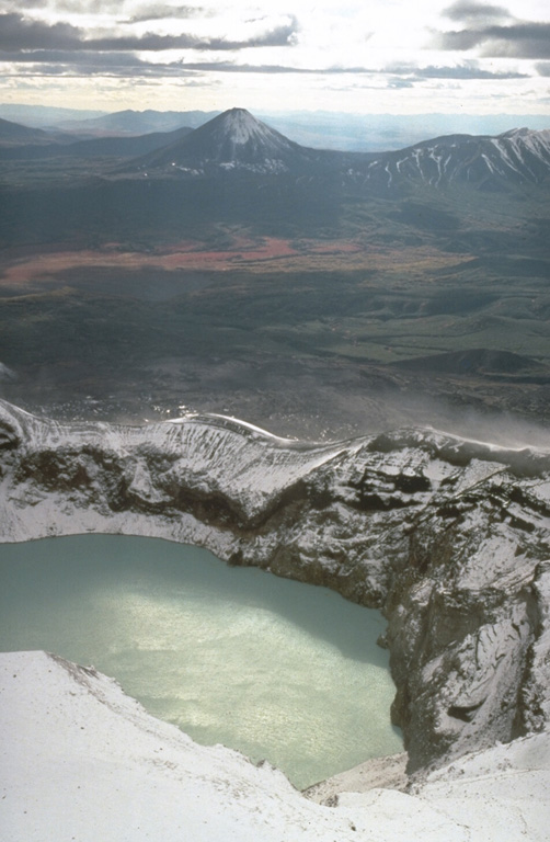 An acidic lake occupies Troitsky crater, the youngest and southernmost crater of Maly Semyachik where historical eruptions have occurred. The conical peak in the distance is Karymsky, 15 km SW, which was constructed within a Holocene caldera. Photo by Dan Miller, 1990 (U.S. Geological Survey).
