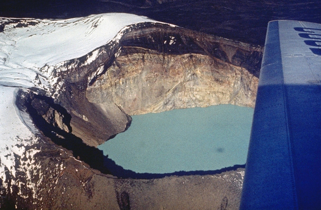 The currently active Troitsky crater of Maly Semiachik formed during an explosive eruption about 400 years ago. The eastern crater wall shows light-colored hydrothermally altered rocks of the vent complex that are overlain by darker lava flows and fall deposits from eruptions that followed formation of the crater. A hot, acidic lake now fills the crater, which has been the source of historical eruptions. Photo by Oleg Volynets (Institute of Volcanology, Petropavlovsk).