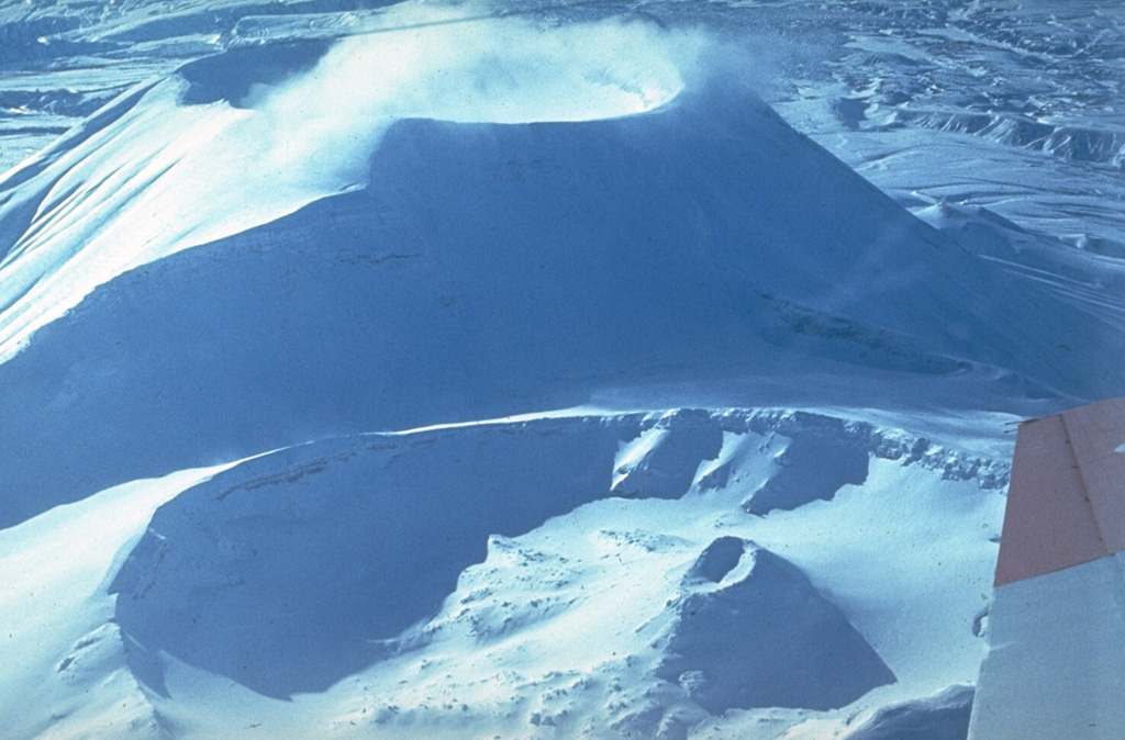 The northern (bottom) and southern (top) cones at the summit of Krasheninnikov were constructed within a 9-km-wide late-Pleistocene caldera. The southern cone began forming about 11,000 years ago and the northern cone about 6,500 years ago; both have 800-m-wide craters. An eruption about 400 years ago produced the small Pauk cone within the northern crater (lower right). Photo by Yuri Doubik (Institute of Volcanology, Petropavlovsk).